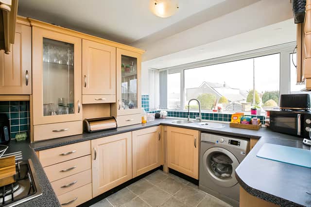 The functional kitchen provides good storage and preparation space, with a utility area adding further practicality