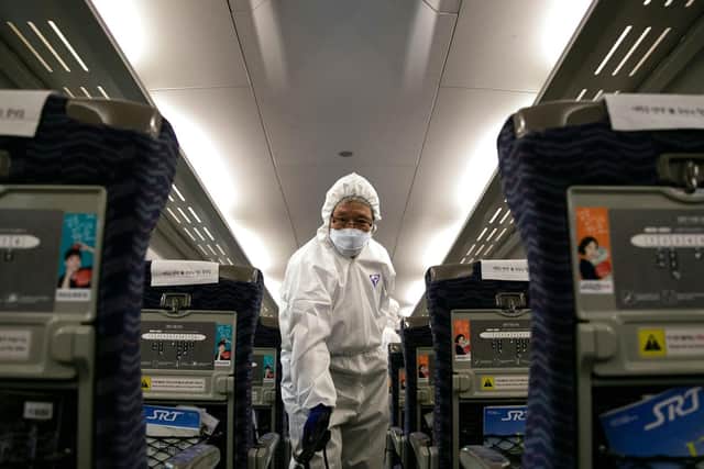 A worker from a cleaning and disinfection service sprays disinfectant in a train as part of efforts to prevent the spread of a new virus which originated in the Chinese city of Wuhan (Photo by HONG YOON-GI/AFP via Getty Images)