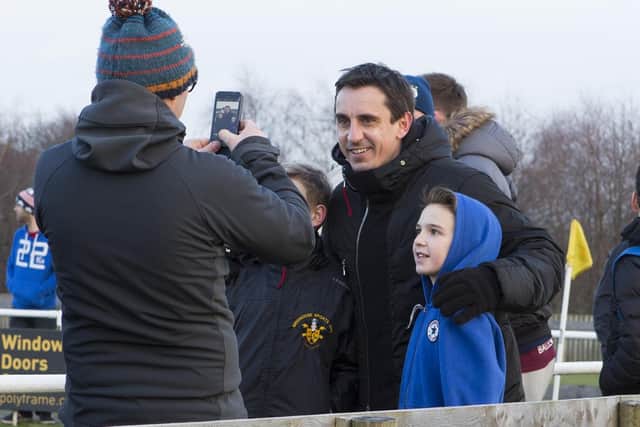 Gary Neville poses with young fans at Brighouse Town FC, during the visit from Salford City FC