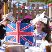 Olivia Meleschko holds painting of a union jack during a VE Day anniversary picnic at Shelf Junior and Infants School, Halifax, which remains open for around eight children of key workers.