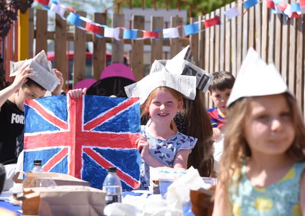 Olivia Meleschko holds painting of a union jack during a VE Day anniversary picnic at Shelf Junior and Infants School, Halifax, which remains open for around eight children of key workers.