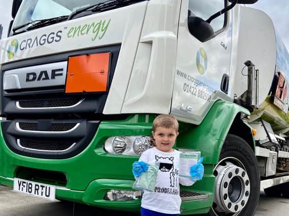 Sam Duckworth proudly stands next to a Craggs Tanker with
a box of Face Covers.