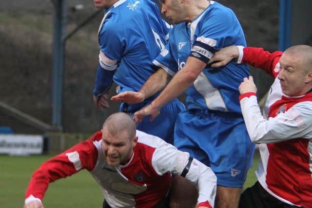 Bower goes for a header against Ashton United at the Shay