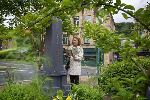Incredible Edible Todmorden volunteer Liz Thorpe by the little library built as a nod to the nearby landmark Stoodley Pike. Picture Tony Johnson