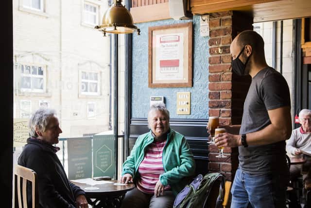 Jim Aspden, right, serves Brenda Branham, left, and Adele Haimsworth, centre, at the Victorian Craft Beer Cafe, Halifax.