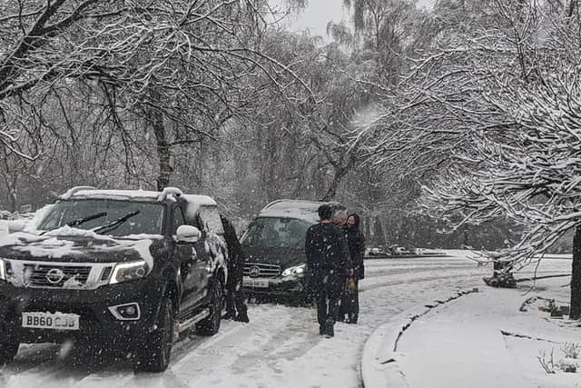 Mourners rolled up their sleeves and helped carry a gentleman on his final journey at a funeral in Elland, Halifax, yesterday after the hearse became stuck in the snow