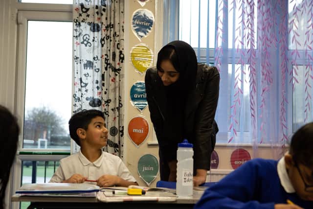 Calderdale primary schools who have been forced to take in large 'bubbles' of children because parents don't have access to computers/internet at home or the children are classed as vulnerable. Pictured is teacher Khansa Ali, with a child at Parkinson Lane Primary School, Halifax