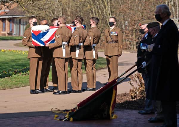 BEDFORD, ENGLAND - FEBRUARY 27: (No reuse after 11.59pm on March 6th 2021 without written consent from gemma@captaintom.org.) The coffin of Captain Sir Tom Moore is carried by members of the Armed Forces during his funeral at Bedford Crematorium on February 27, 2021 in Bedford, England. WWII veteran, Sir Tom raised nearly £33 million for NHS charities ahead of his 100th birthday last year by walking laps of his garden in Marston Moretaine, Bedfordshire. He died on the 2nd of February after testing positive for COVID-19. (Photo by Joe Giddens - Pool/Getty Images)