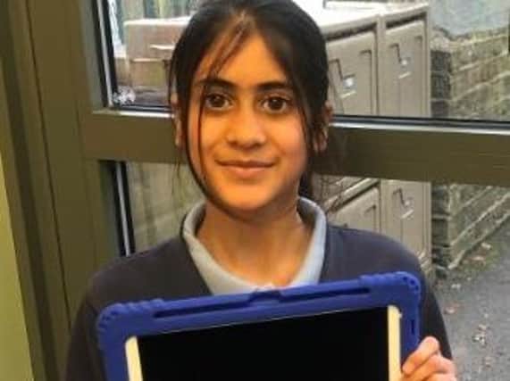 School student holding one of the newly gifted ipads funded by Rotary.