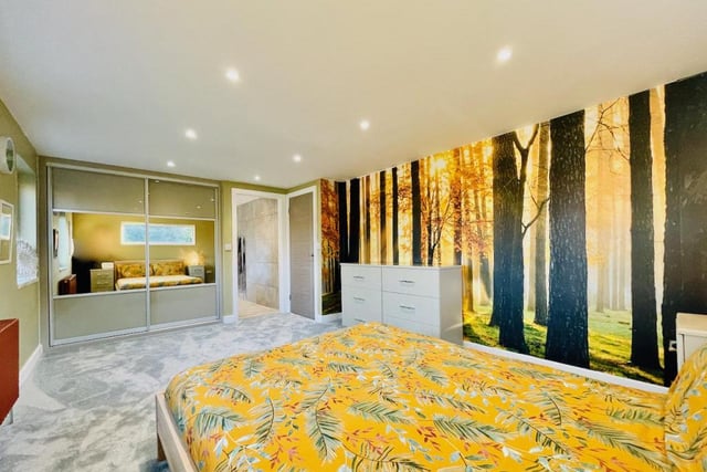 This large bedroom with woodland wallpaper comes with an equally big bathroom suite