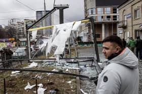 KYIV, UKRAINE - FEBRUARY 24: People stand around a damaged structure caused by a rocket on February 24, 2022 in Kyiv, Ukraine. Overnight, Russia began a large-scale attack on Ukraine, with explosions reported in multiple cities and far outside the restive eastern regions held by Russian-backed rebels. (Photo by Chris McGrath/Getty Images)