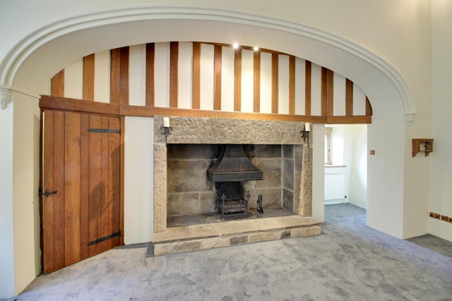 This large stone fireplace, now containing a woodburning stove, is a feature within the property.