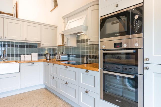 Fitted units and appliances with wooden work tops within the kitchen area, that also has an island feature.