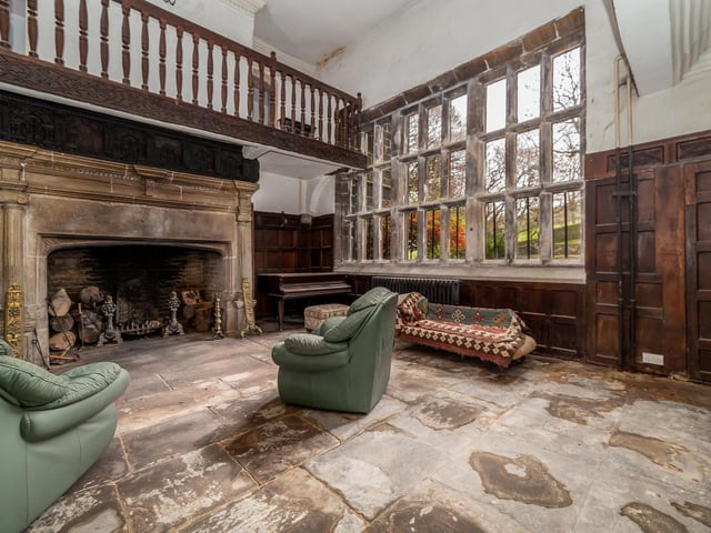 A closer look at the period stone fireplace with gallery above, that dominates this hall.