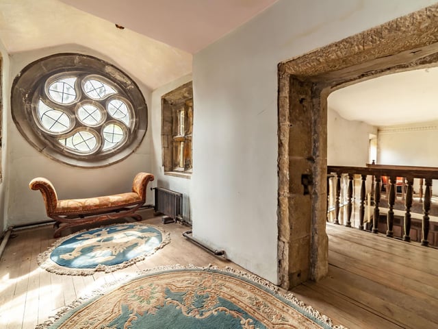 The circular window on the first floor, with stone framed doorway to the gallery landing.