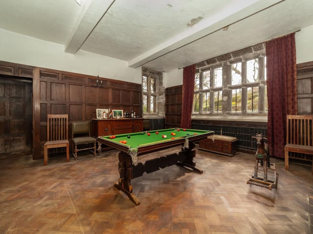 Wood panelling to the walls and parquet flooring in this games room.