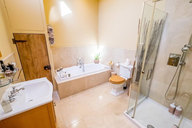 A bathroom with both bath and separate shower, and washbasin with vanity unit.