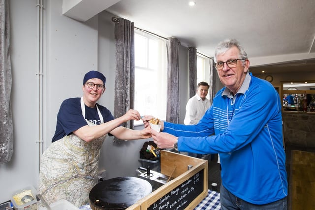 Ian Lindsay from the Rotary Club of Hebden Bridge buys a crepe from Kiki Singer as the championships take place
