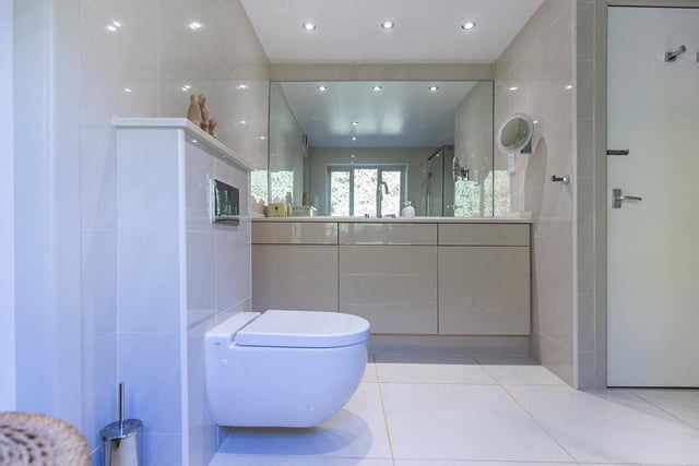A wash basin within a high gloss vanity unit is a feature of the shower room.