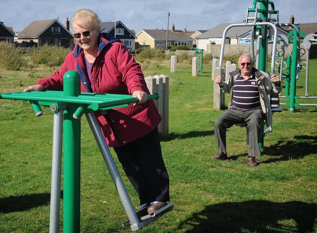 People on outdoor gym equipment