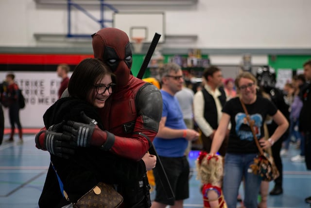 Deadpool gives a visitor a hug at Hali-Con
