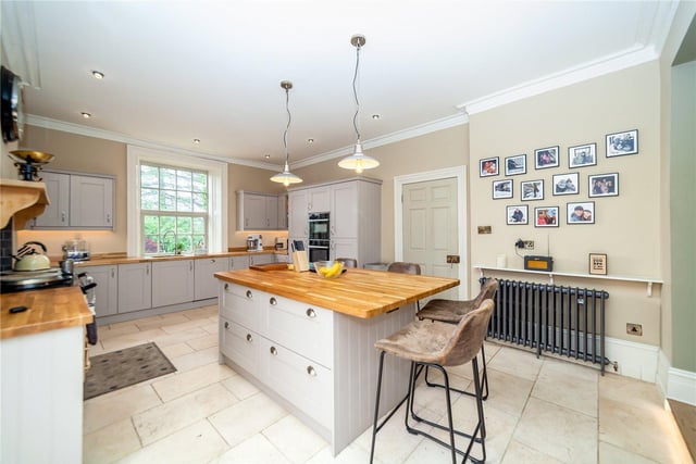 The breakfast kitchen is light and spacious, with windows at each end. It features an island unit, and an Aga stove.