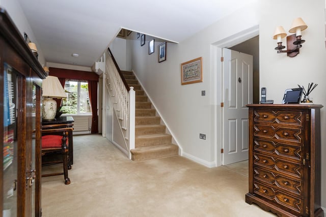 The welcoming hallway with window has a staircase leading up, and plenty of floor space for free standing furniture.