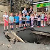 Members of Limelight Theatre school with a huge sink hole outside their building