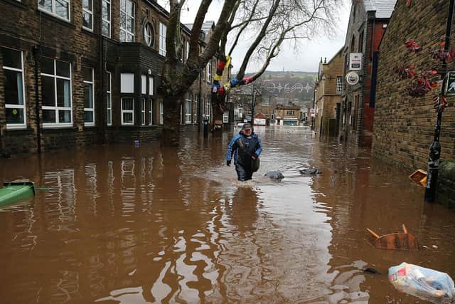 A  man wades through floodwaters as rivers burst their banks on December 26, 2015 in Hebden Bridge (Getty Images)
