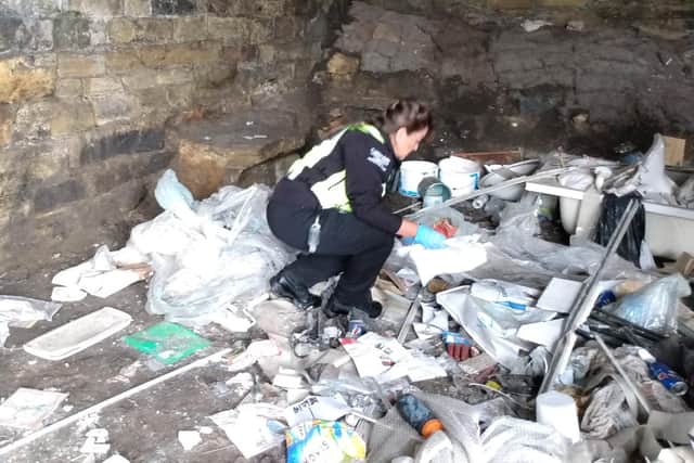 Checking illegally dumped rubbish at North Bridge, Halifax, for information which might be traceable