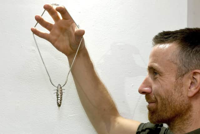 Jeweller and silversmith  Tony  Cotterill  from Hebden Bridge  with his silver insect  pendant