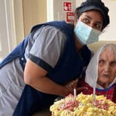 Pritum with her cake and a member of staff from her care home