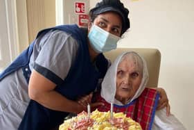Pritum with her cake and a member of staff from her care home