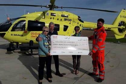 Loraine Greenwood from Halifax hands over the money to the Yorkshire Air Ambulance