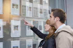 Side view of a young couple looking at window display at real estate office. Picture: stock.adobe.com