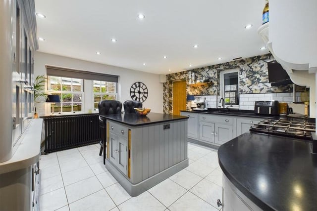 A spacious modern kitchen with bespoke units and granite worktops.