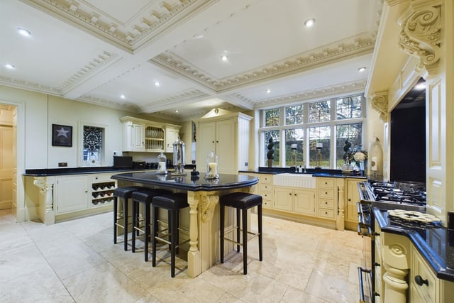 The kitchen has shaker-style units and granite worktops, with integrated appliances and a central island.