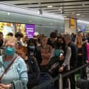 Travellers wait in a long queue to pass through the security check. (Photo by Carl Court/Getty Images)