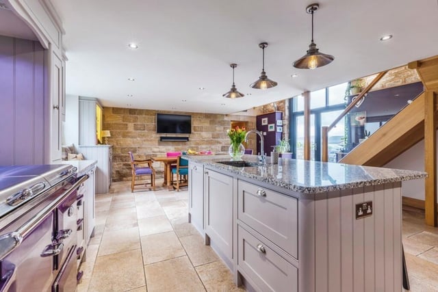 The kitchen with diner features a large central island,and granite worktops, with access out to a patio.