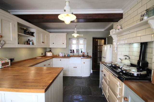The traditional style dining kitchen has bespoke, hand made wooden units with an integrated dishwasher and a gas Aga range cooker.