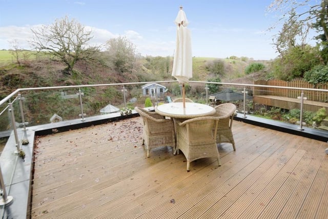 This spacious decked balcony, that is accessed from the dining area, overlooks the garden and beyond.