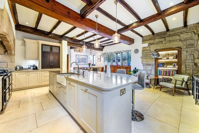 A hand-built, modern kitchen is open plan with breakfast bar and dining area.