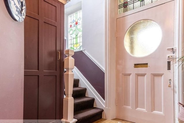 A hallway with staircase leading up, leads in to the property.