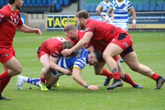 1. Zack McComb, on his 100th career appearance, is tackled by three London Broncos players.