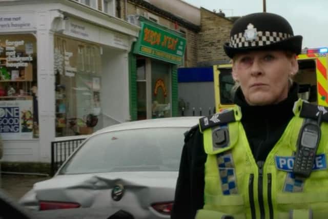 Sarah Lancashire as Sergeant Catherine Cawood in Happy Valley series one with a Forget Me Not Children’s Hospice charity shop in the background. Picture: BBC