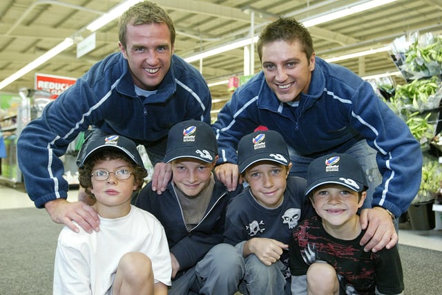 Halifax rugby league stars appearing at ASDA - Damian Ball, left and Damian Gibson with, from the left, Oscar Corcos, nine, Louis Corcos, 12, Max Corcos, 11 and Jude Corcos, six, wearing the HRLFC caps they have been given