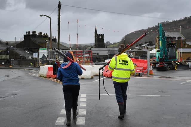 A flood warden carries scaffolding as residents begin clearing up following severe flooding beside the River Calder on February 10, 2020 in Mytholmroyd. Photo by Anthony Devlin/Getty Images.