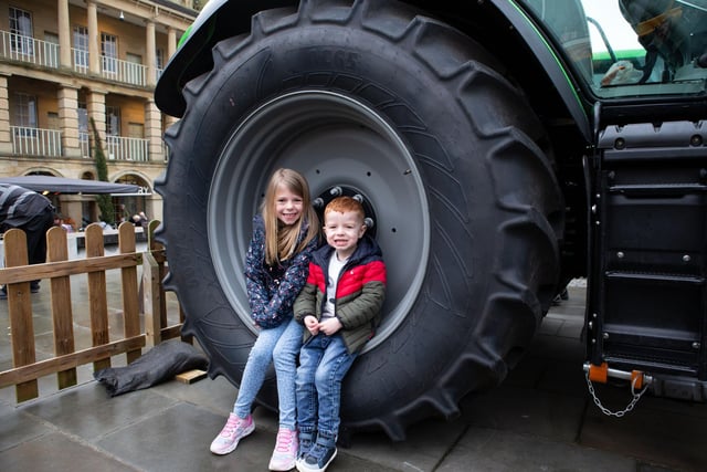 Eliza and Oscar Appleby in the wheel at tractors and farm vehicles in the courtyard at The Piece Hall, Halifax