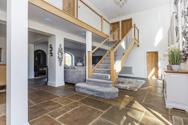 An oak and glazed staircase leads up from the ground floor's open plan hallway.