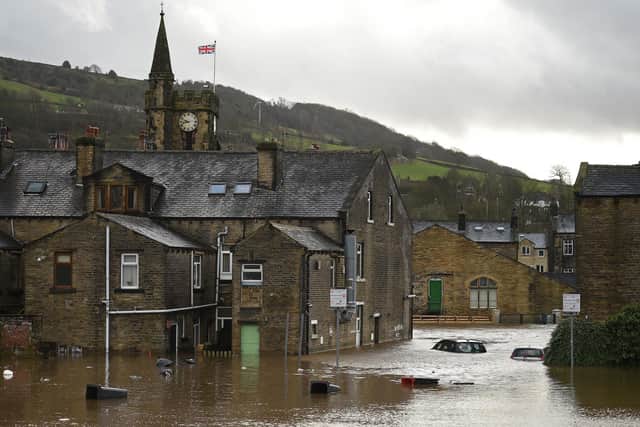 Submerged cars and floating wheelie bins are pictured in a flooded street in Mytholmroyd, on February 9, 2020, after the River Calder burst its banks as Storm Ciara swept over the country. Photo by Oli SCARFF / AFP